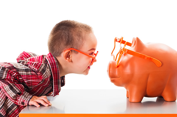 little boy with glasses looking at piggy bank with fun glasses