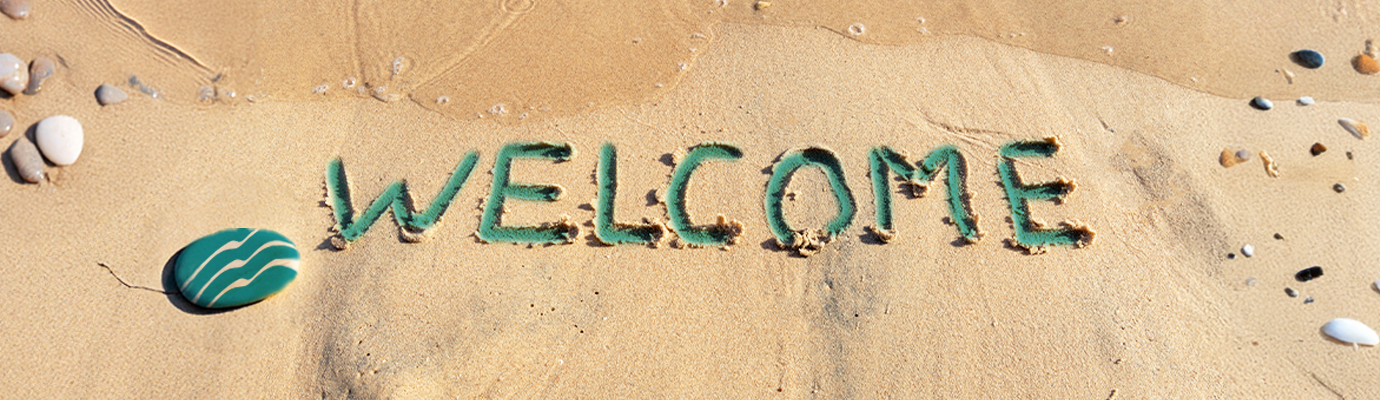 Welcome written in the sand